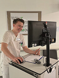 Ein Foto  von Pflegefachmann Clemens Reiche bei der Dokumentation der Patientendaten.