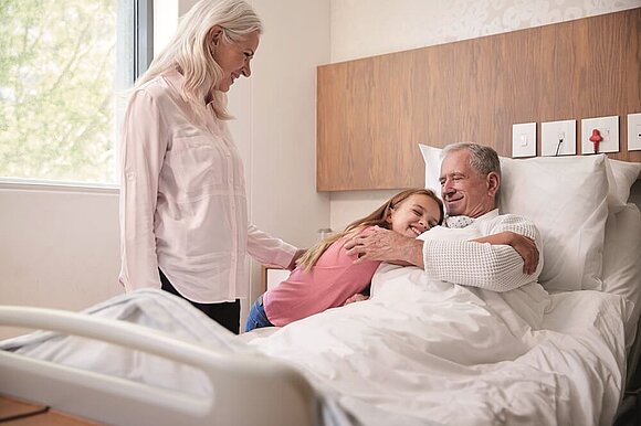 Foto von einer Mutter mit Kind, die ein Familienmitglied im Krankenhaus besucht