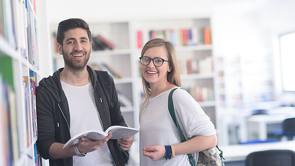Zwei Studenten in einer Bibliothek.